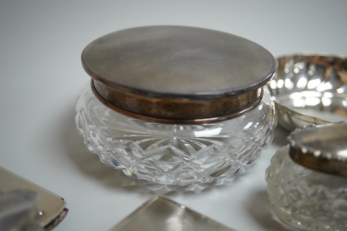 An 835 standard engine turned white metal powder compact, 72mm, three silver mounted glass toilet jars, two silver mounts and an Italian 800 standard small dish.